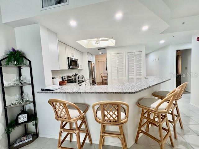 3020 Matecumbe Key Road, Unit 103 Punta Gorda, FL 33955 - Photo 14 of 55 a kitchen with granite countertop wooden cabinets and a stainless steel appliances