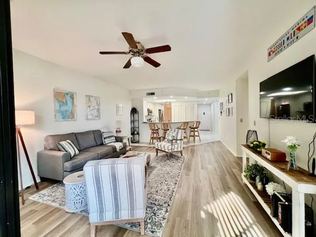 a living room with furniture large window and wooden floor