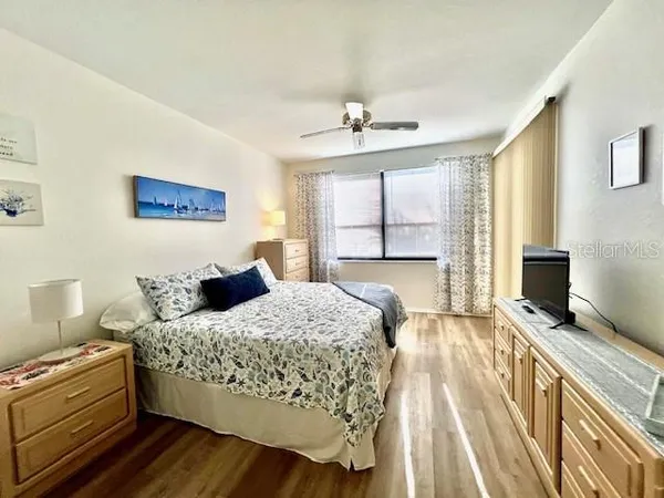 a bedroom with a bed a dresser and flat screen tv