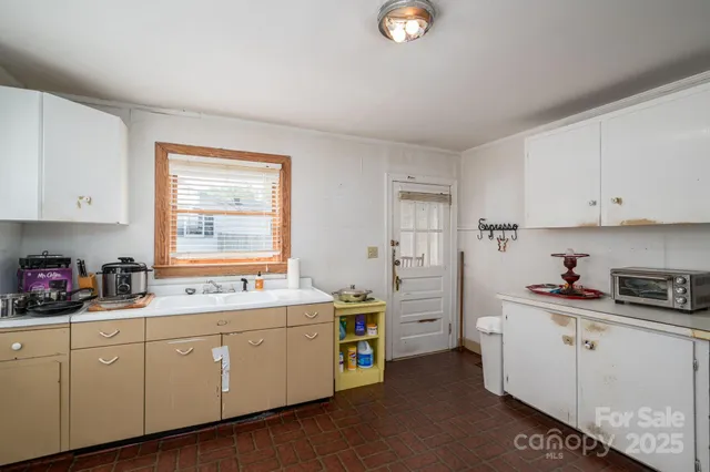 a kitchen that has a lot of cabinets in it and wooden floors