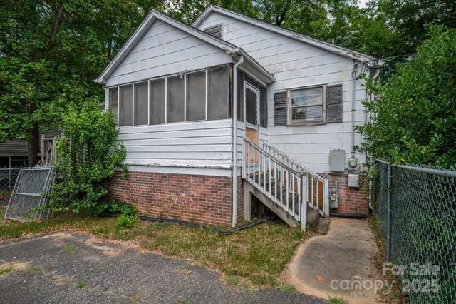 a white house that has tree in front of it