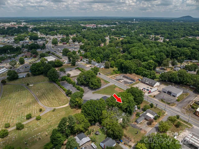 an aerial view of residential house with outdoor space and trees all around
