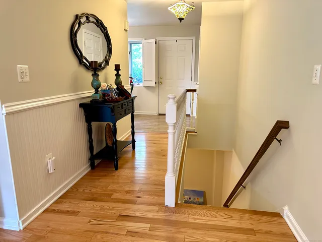 a view of a hallway with wooden floor and entryway
