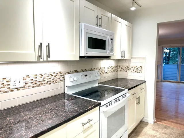 a kitchen with stainless steel appliances granite countertop a sink and a stove
