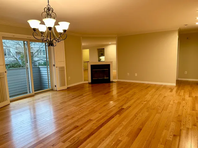 a view of a livingroom with wooden floor and a chandelier