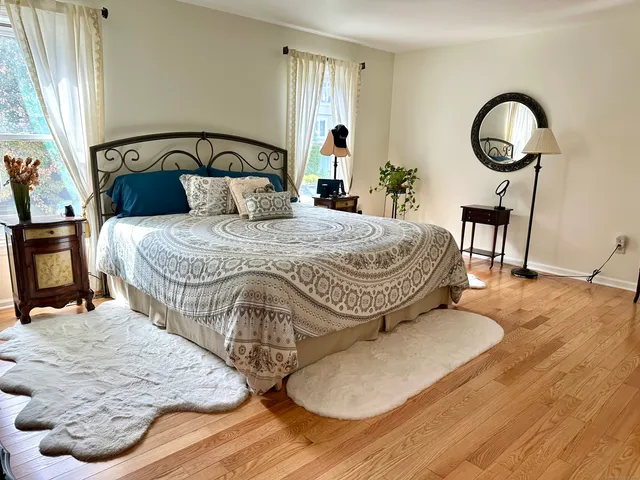 a bedroom with a bed and wooden floor