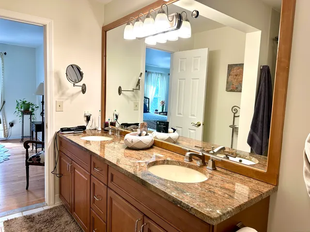 a bathroom with a granite countertop sink and a mirror