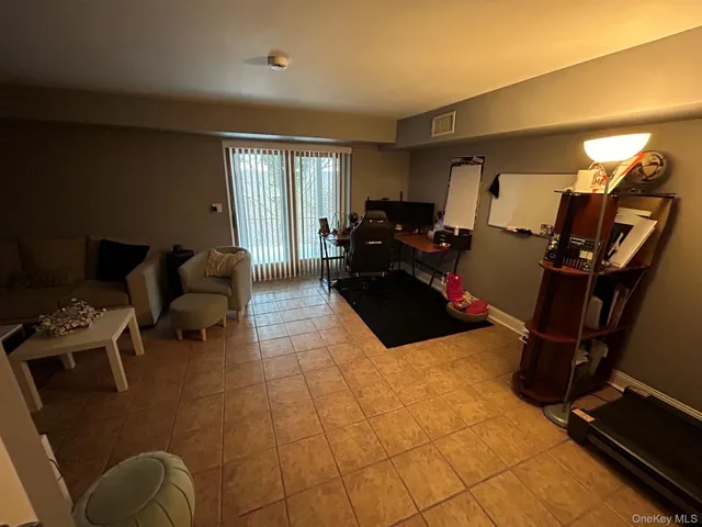 a living room with furniture a air conditioner vent and a window