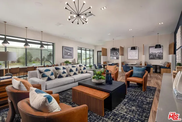 a living room with furniture potted plant and a large window