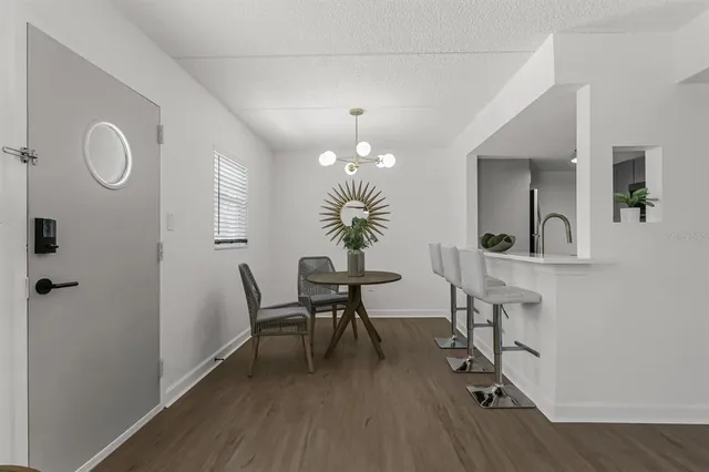 a dining room with chandelier fan and wooden floor