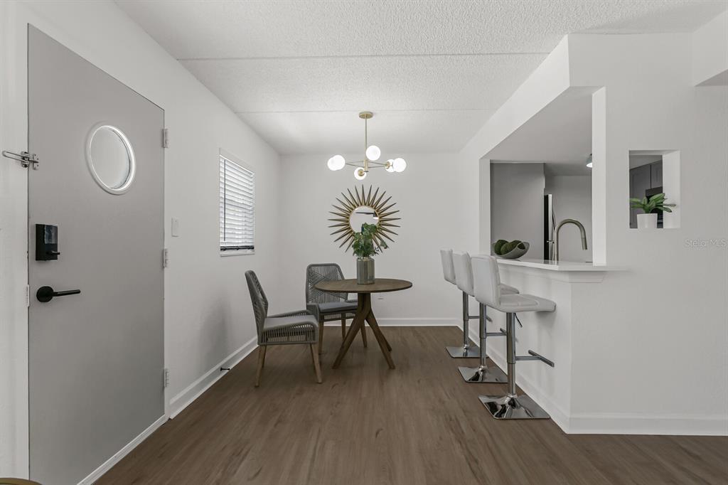 807 South Howard Avenue, Unit 105 Tampa, FL 33606 - Photo 12 of 15 a dining room with chandelier fan and wooden floor