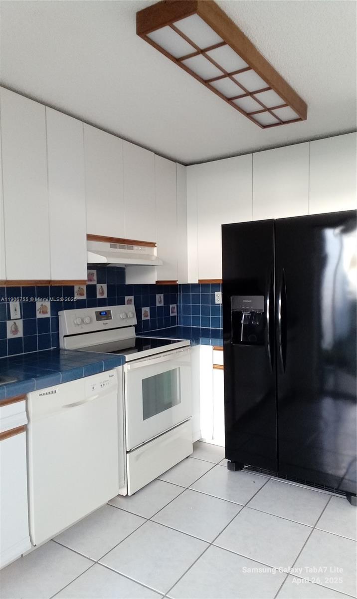 13764 Southwest 149th Cir Lane, Unit 1 Miami, FL 33186 - Photo 13 of 16 a kitchen with granite countertop a refrigerator and a stove top oven