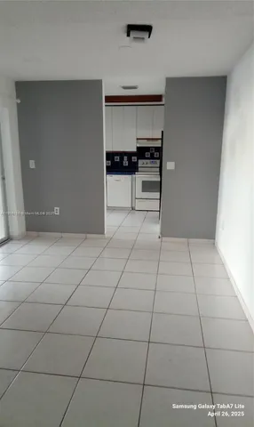 a view of kitchen with refrigerator and cabinets