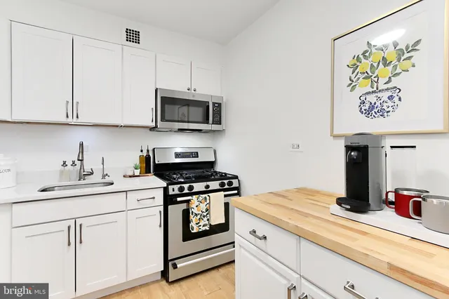 a kitchen with stainless steel appliances granite countertop a sink and a stove