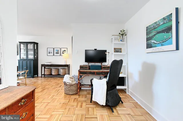 a living room with furniture a flat screen tv and kitchen view