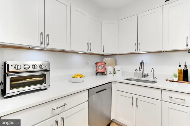 a kitchen with white cabinets and a sink