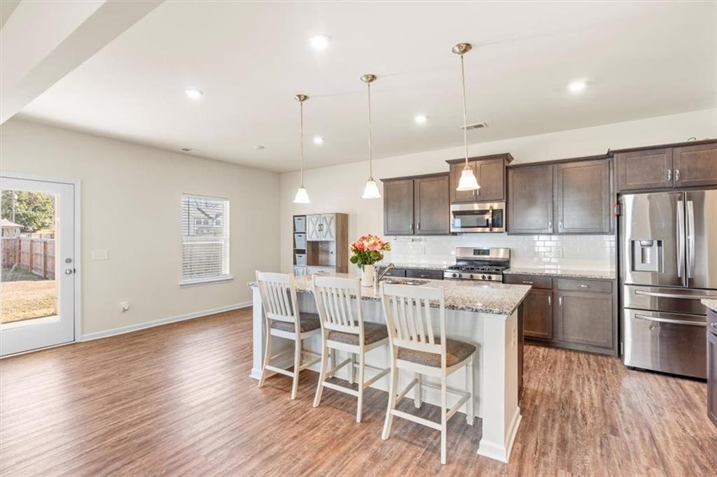 401 Larry Lane Adairsville, GA 30103 - Photo 10 of 41 a kitchen with stainless steel appliances granite countertop a dining table chairs refrigerator and microwave