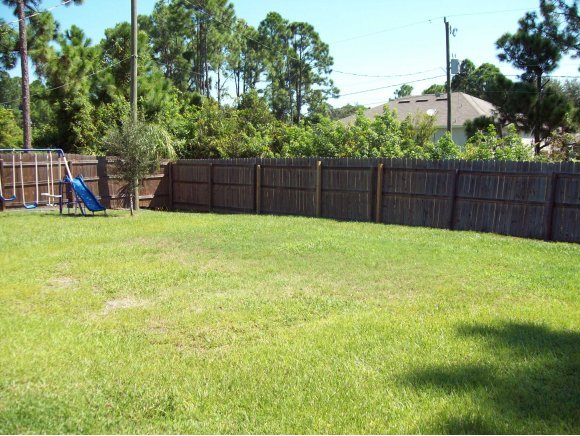 331 Southwest Santa Rosa Palm Bay, FL 32908 - Photo 7 of 10 a view of backyard with wooden fence and trees