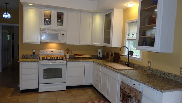489 Market Hill Road Amherst, MA 01002 - Photo 14 of 27 a kitchen with granite countertop a sink a stove and cabinets