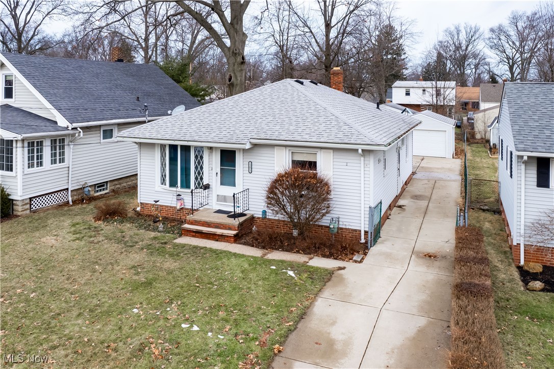 Back of house with a yard, a garage, and an outdoor structure
