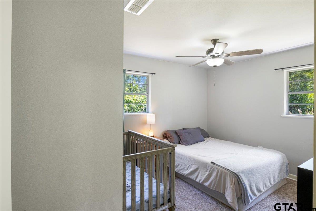 10638 County Road 384 Tyler, TX 75708 - Photo 16 of 33 a bedroom with a bed and a ceiling fan