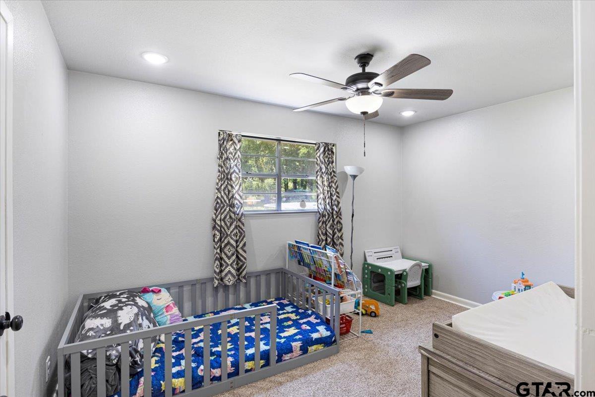 10638 County Road 384 Tyler, TX 75708 - Photo 18 of 33 a bedroom with a bed and a chandelier