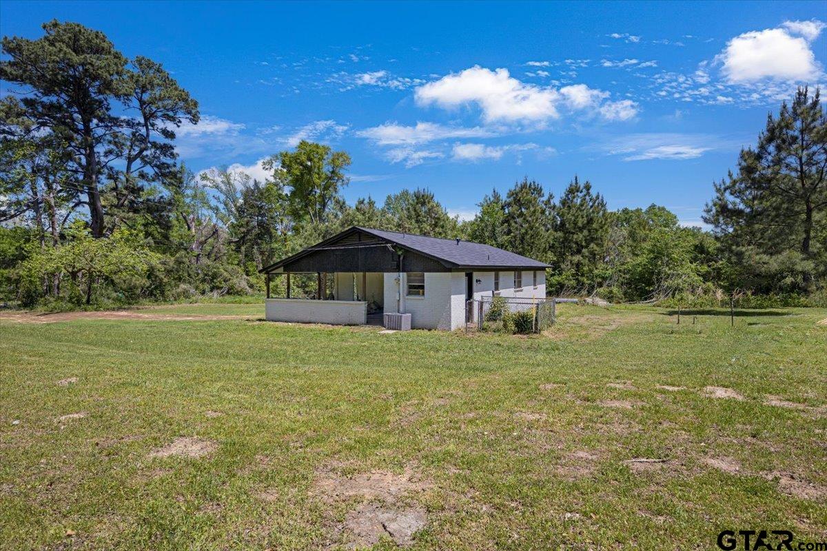 10638 County Road 384 Tyler, TX 75708 - Photo 20 of 33 a yellow house with green field in front of it
