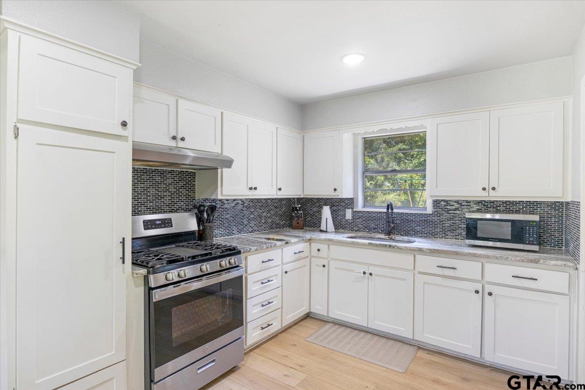 10638 County Road 384 Tyler, TX 75708 - Photo 7 of 33 a kitchen with granite countertop white cabinets stainless steel appliances and a sink