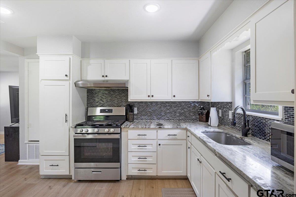 10638 County Road 384 Tyler, TX 75708 - Photo 9 of 33 a kitchen with granite countertop a stove sink and cabinets