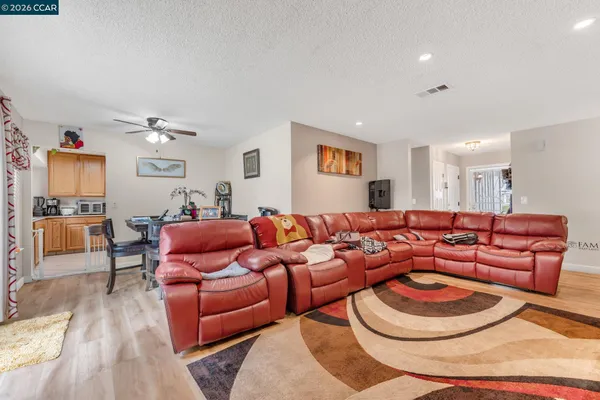 a living room with furniture and a wooden floor