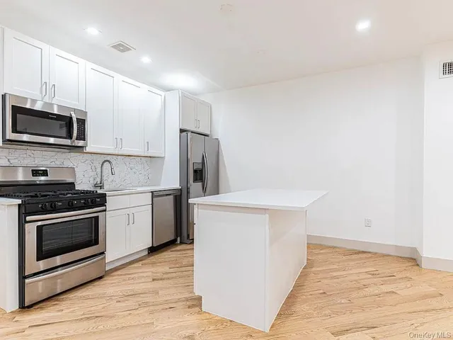 a kitchen with stainless steel appliances a white stove top oven and refrigerator
