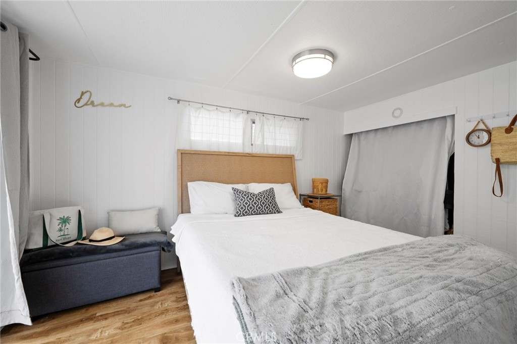 6550 Ponto Drive, Unit 17 Carlsbad, CA 92011 - Photo 27 of 48 a bedroom with a bed and wooden floor