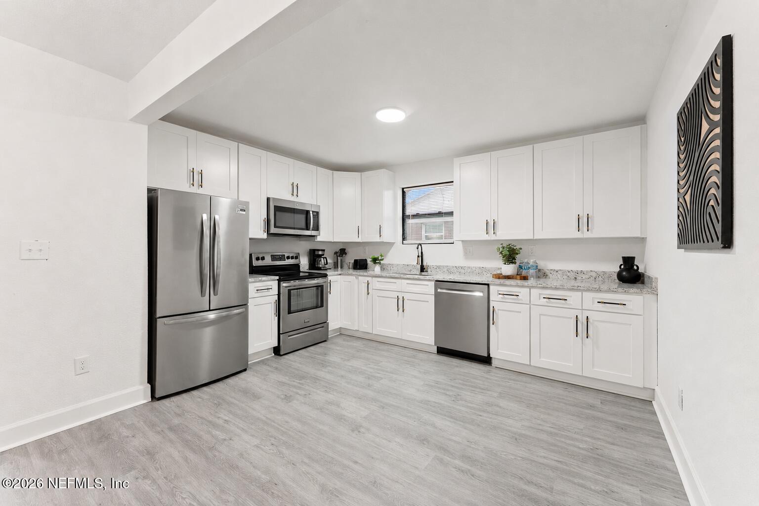 2131 Redfern Road Jacksonville, FL 32207 - Photo 7 of 13 a kitchen with granite countertop white cabinets and stainless steel appliances