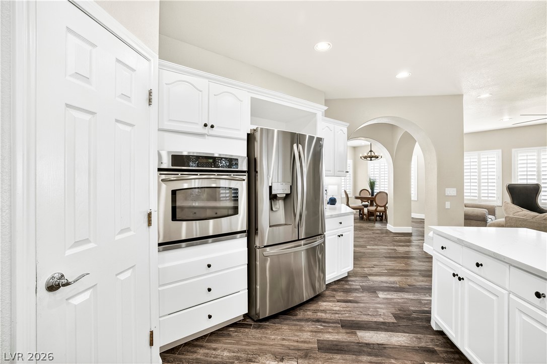 1135 Calico Ridge Drive Henderson, NV 89011 - Photo 22 of 86 A well-appointed kitchen features stainless steel appliances and crisp white cabinetry, opening to an inviting living area.
