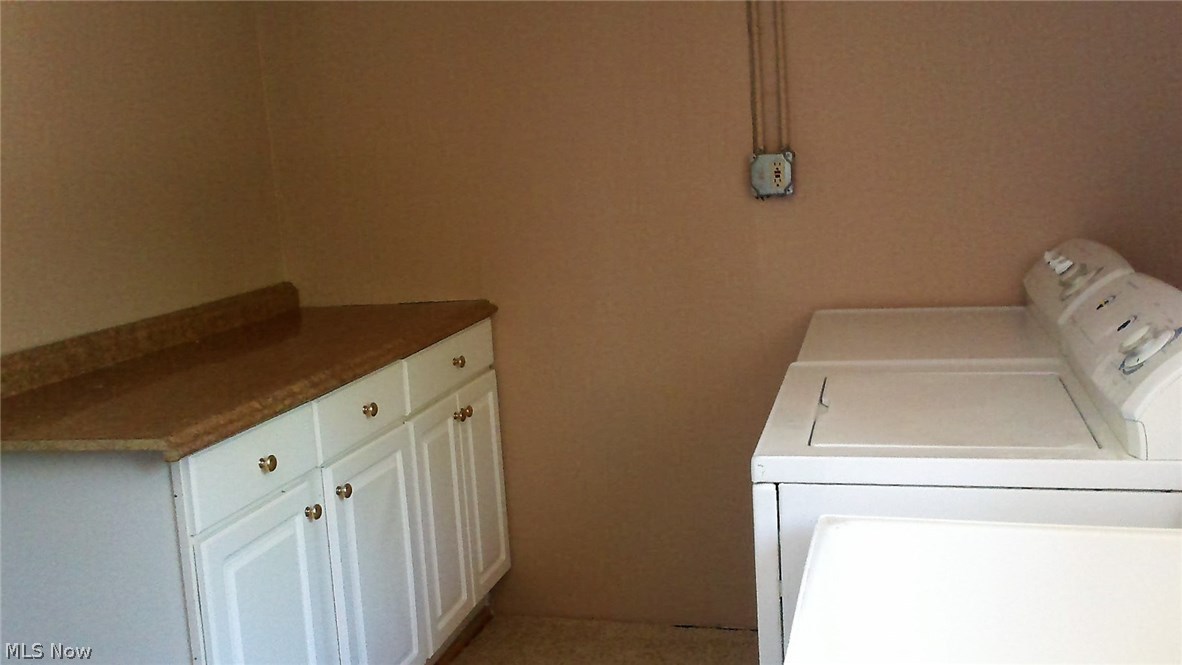 22761 Drake Road Bedford, OH 44146 - Photo 21 of 21 Spacious Laundry Room with tub, and folding table and cabinets Dryer included washer does not work and will be removed