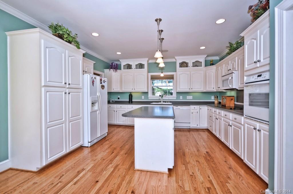 5406 Morgan Mill Road, Unit 2 Monroe, NC 28110 - Photo 7 of 23 a kitchen with stainless steel appliances kitchen island granite countertop a refrigerator a oven a sink and white cabinets with wooden floor