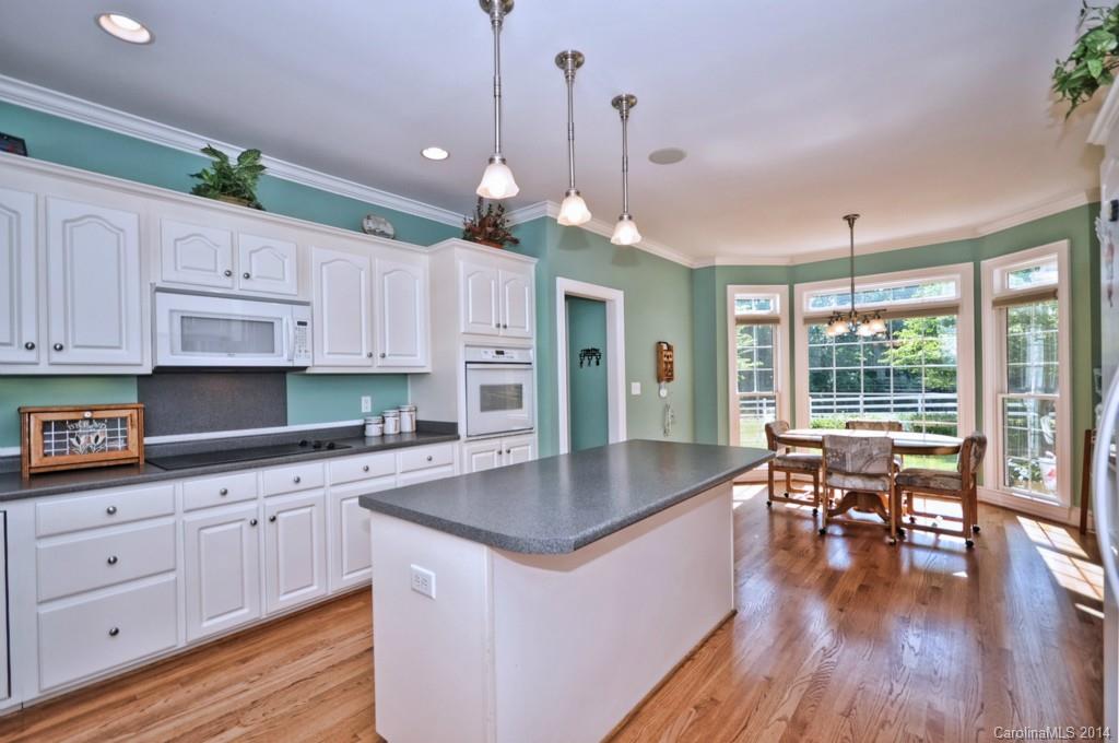 5406 Morgan Mill Road, Unit 2 Monroe, NC 28110 - Photo 8 of 23 a kitchen with white cabinets center island and stainless steel appliances