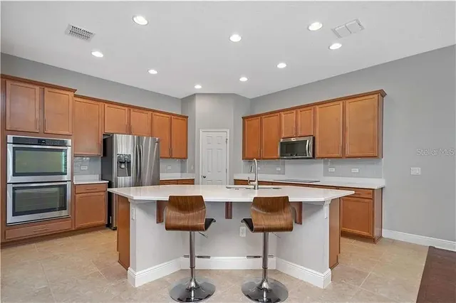 a kitchen with stainless steel appliances kitchen island granite countertop a sink and cabinets