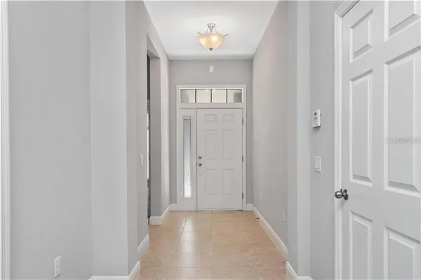 a view of a hallway with wooden floor and a livingroom