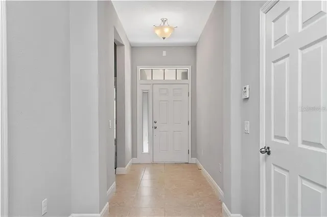 a view of a hallway with wooden floor and a livingroom