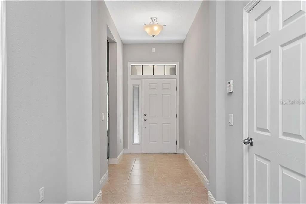 8752 Powder Ridge Trail Windermere, FL 34786 - Photo 5 of 31 a view of a hallway with wooden floor and a livingroom