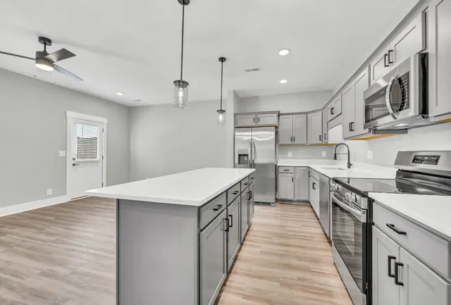 a kitchen with stainless steel appliances a sink a stove top oven a counter space and cabinets