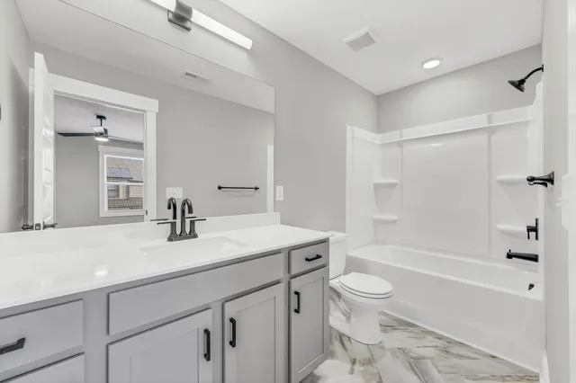 a bathroom with a sink a toilet and a large mirror