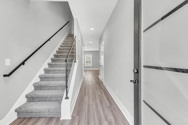 a view of a hallway with wooden floor and staircase