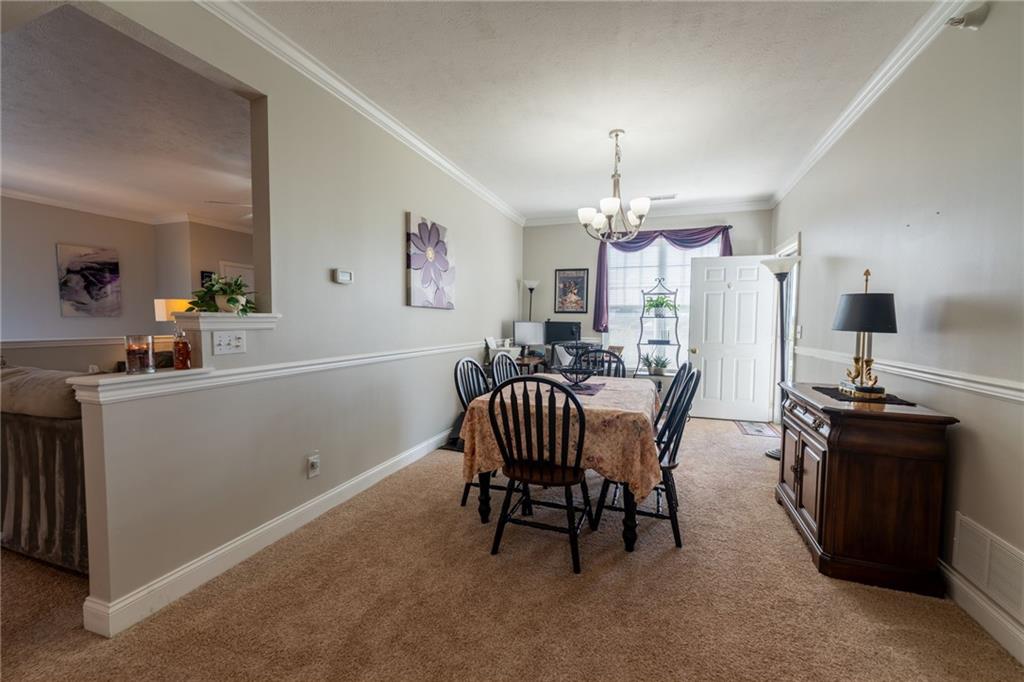 219 Adams Pointe Boulevard, Unit 9 Mars, PA 16046 - Photo 5 of 26 Dining room off the kitchen with chair rail and crown molding. Door to covered balcony area with amazing views.