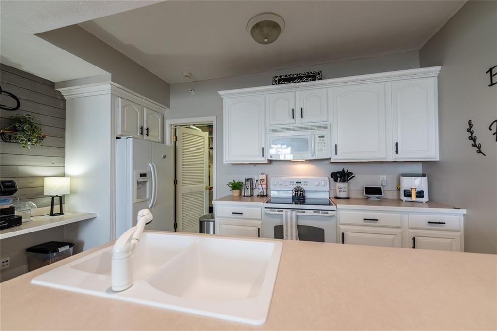 219 Adams Pointe Boulevard, Unit 9 Mars, PA 16046 - Photo 7 of 26 The kitchen features freshly painted cabinets, a dishwasher, electric stove, microwave, refrigerator, garbage disposal, and a desk area.