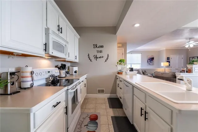 a kitchen with a sink dishwasher stove and cabinets