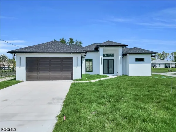 a front view of a house with a yard and garage