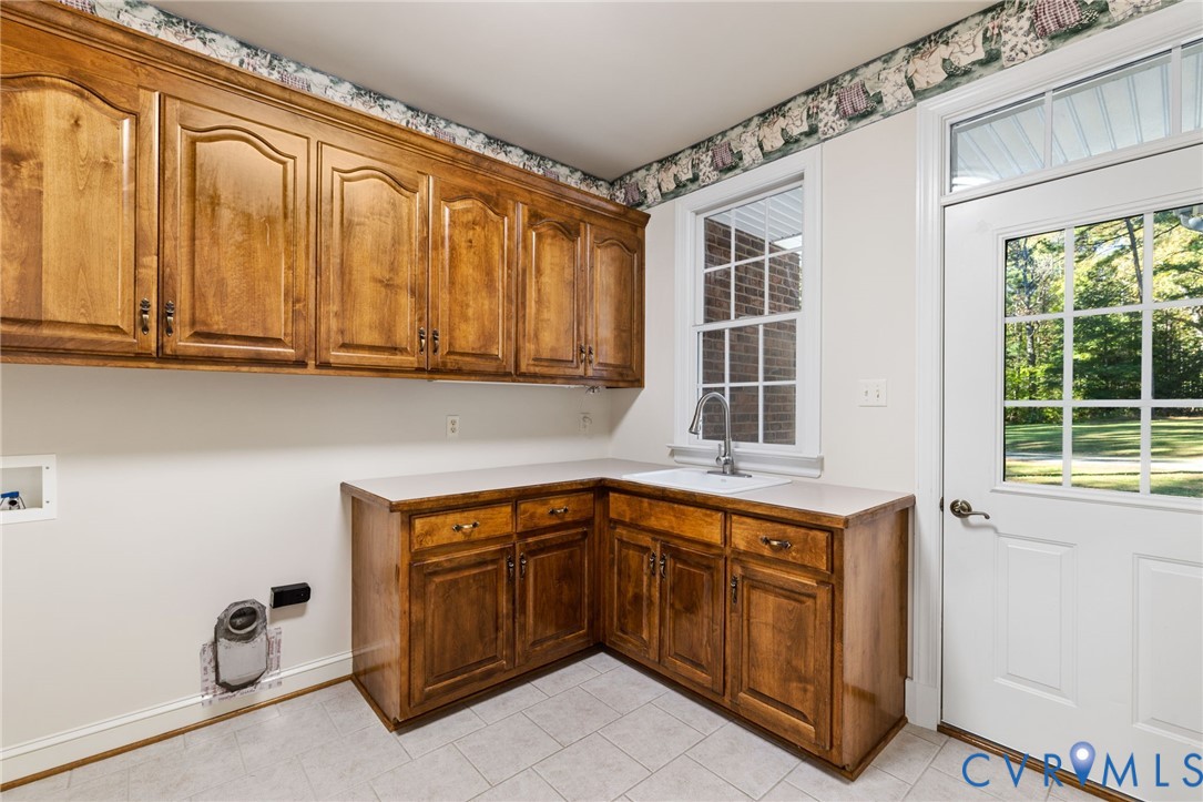 104 Petersburg Road Powhatan, VA 23139 - Photo 27 of 45 a utility room with stainless steel appliances granite countertop a sink and cabinets with wooden floor