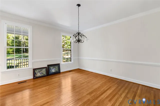 a view of a room with wooden floor fireplace and windows